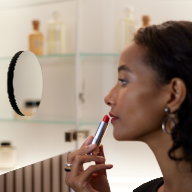 Aynada makyaj yapan kadın