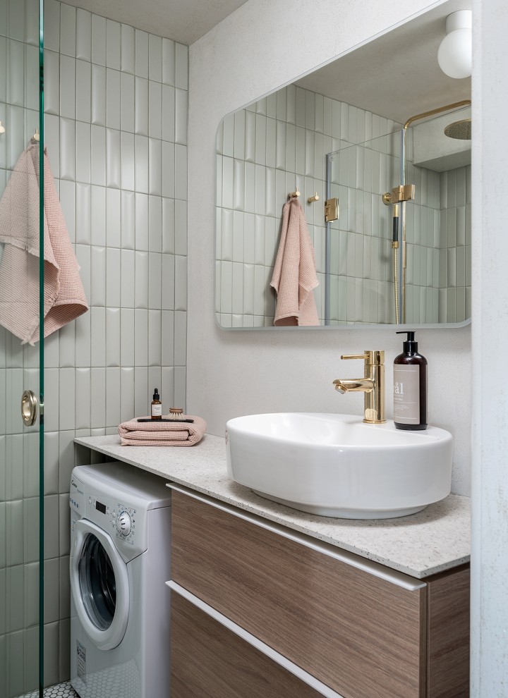 VariForm banyo serisinden oval lavabo ve meşe rengi mobilyalar içeren küçük banyo renovasyonundan sonra (© Meja Hynynen)