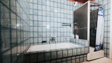 Mavi fayanslı, duşakabinli ve küvetli banyo