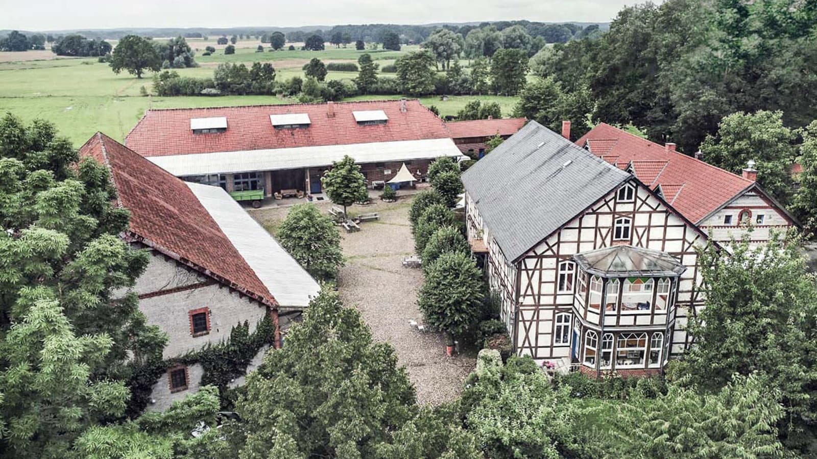 Kuzey Almanya'da Waddeweitz'te geniş bir arazinin üzerinde aralarında ahşap karkaslı bir evin de bulunduğu çeşitli binalar (© Geberit) Kuzey Almanya'da Waddeweitz'te geniş bir arazinin üzerinde aralarında ahşap karkaslı bir evin de bulunduğu çeşitli binalar (© Geberit)